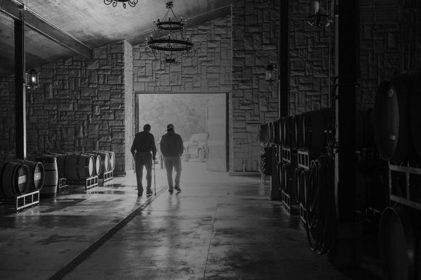 Black and white image of Georges and Daniel in the barrel room