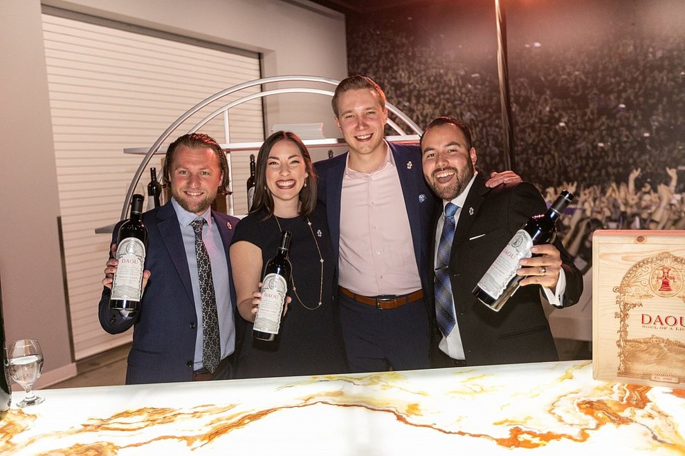 A group of 4 people pose with bottles of DAOU wines