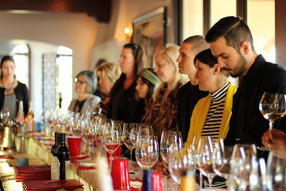 People at a long table wine tasting