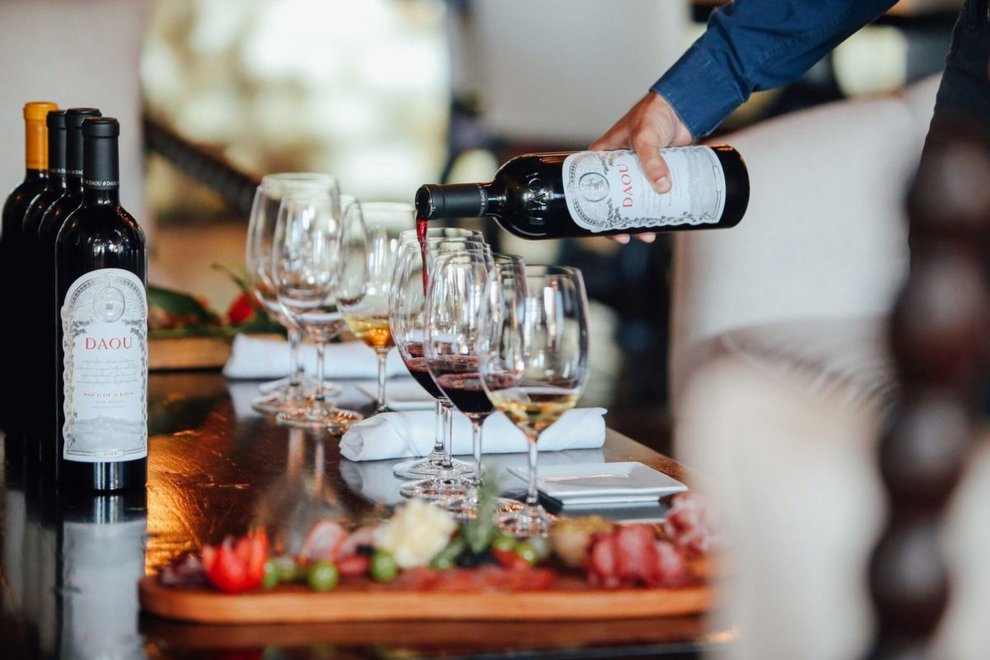 A row of wine bottles with a wine tasting flight 