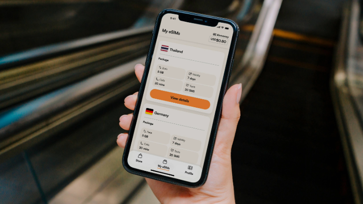 A colour photograph showing a close-up of a woman's hand holding a black mobile phone. On the phone screen, it shows the Airalo travel eSIMs app, with the option of buying an eSIM for Germany displayed. To illustrate a blog post entitled 'Berlin Half Marathon 2026​: Can You Still Register?'