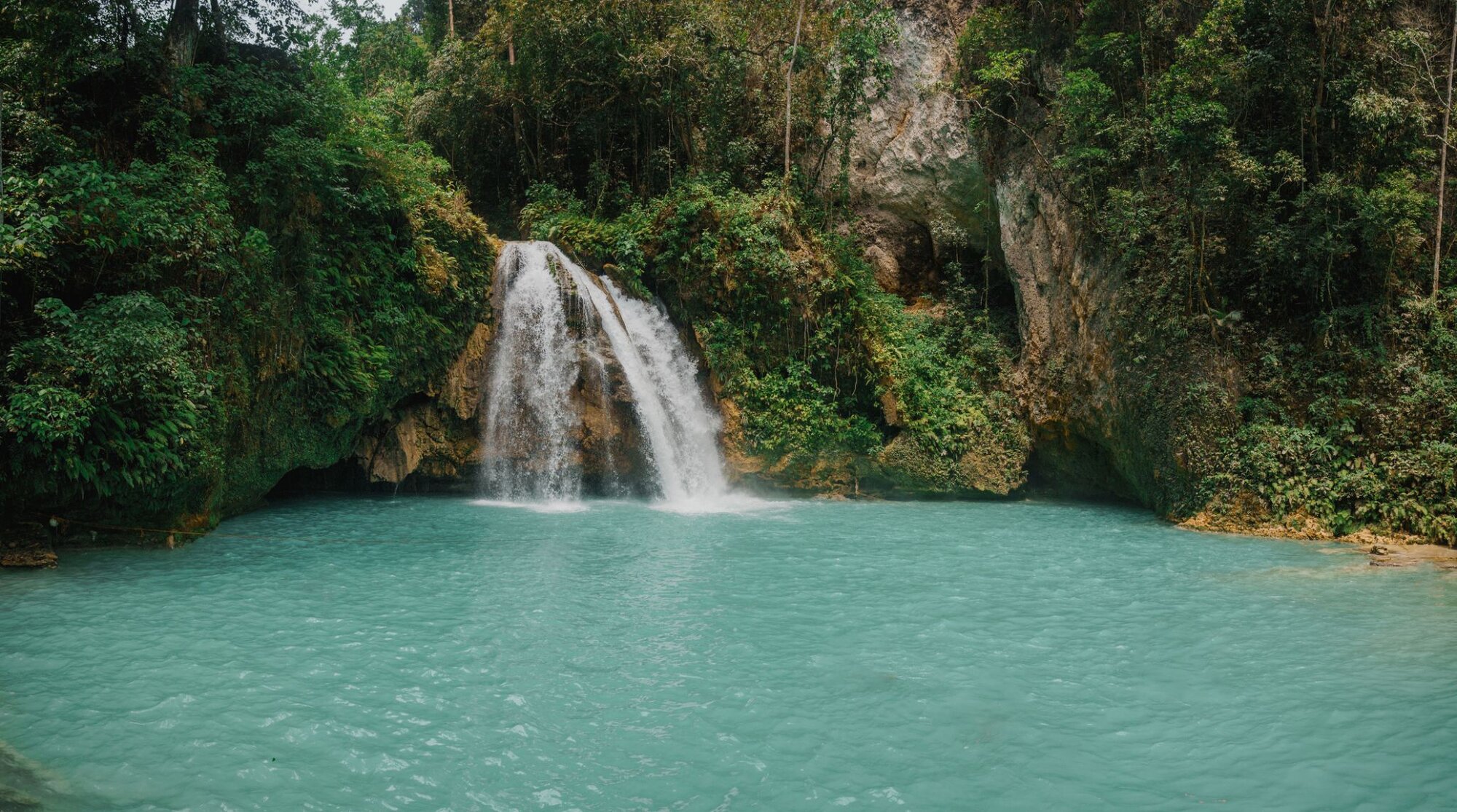 View of Kawasan Falls flowing into a turquoise pool in the jungle of Cebu Island.