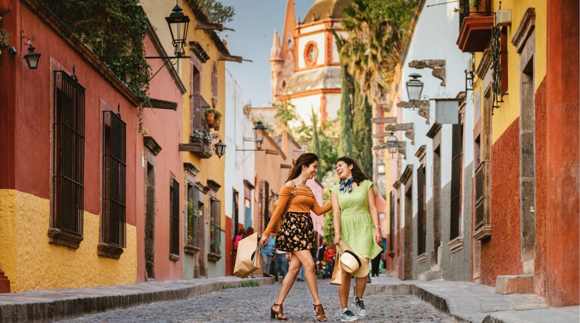 Amigas caminando por una calle colonial en México durante un viaje.