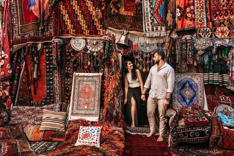 Pareja en una tienda de alfombras en Estambul, de viaje en Turquía.