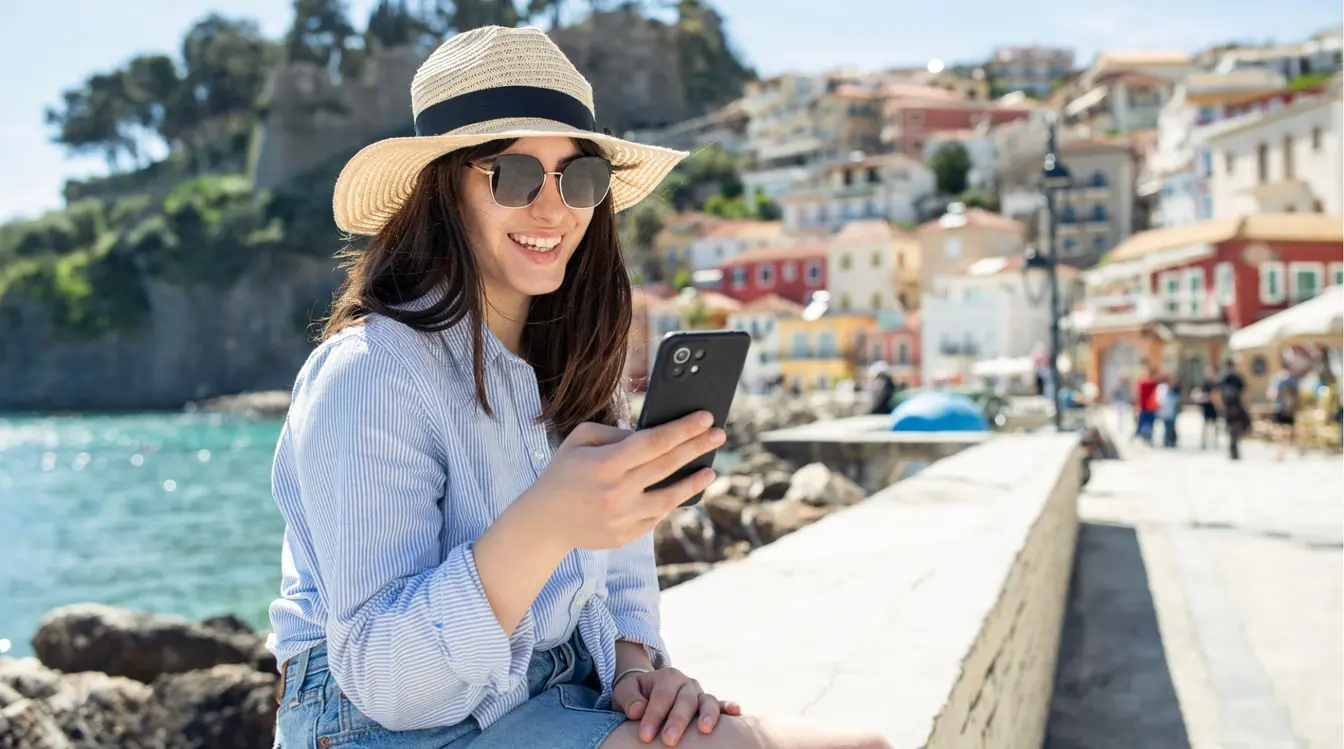 Femme seule en vacances utilisant son téléphone.