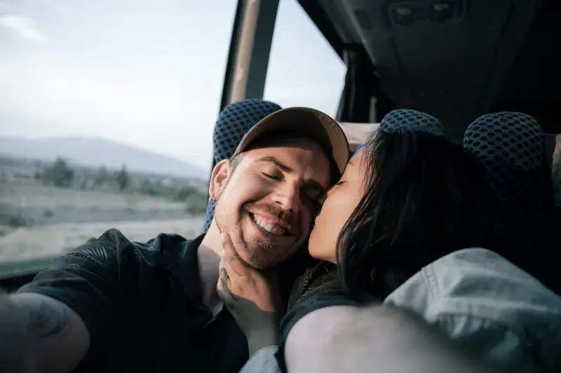 Pareja viajando en autobús hacia la frontera mientras revisa el celular antes de entrar a Estados Unidos.