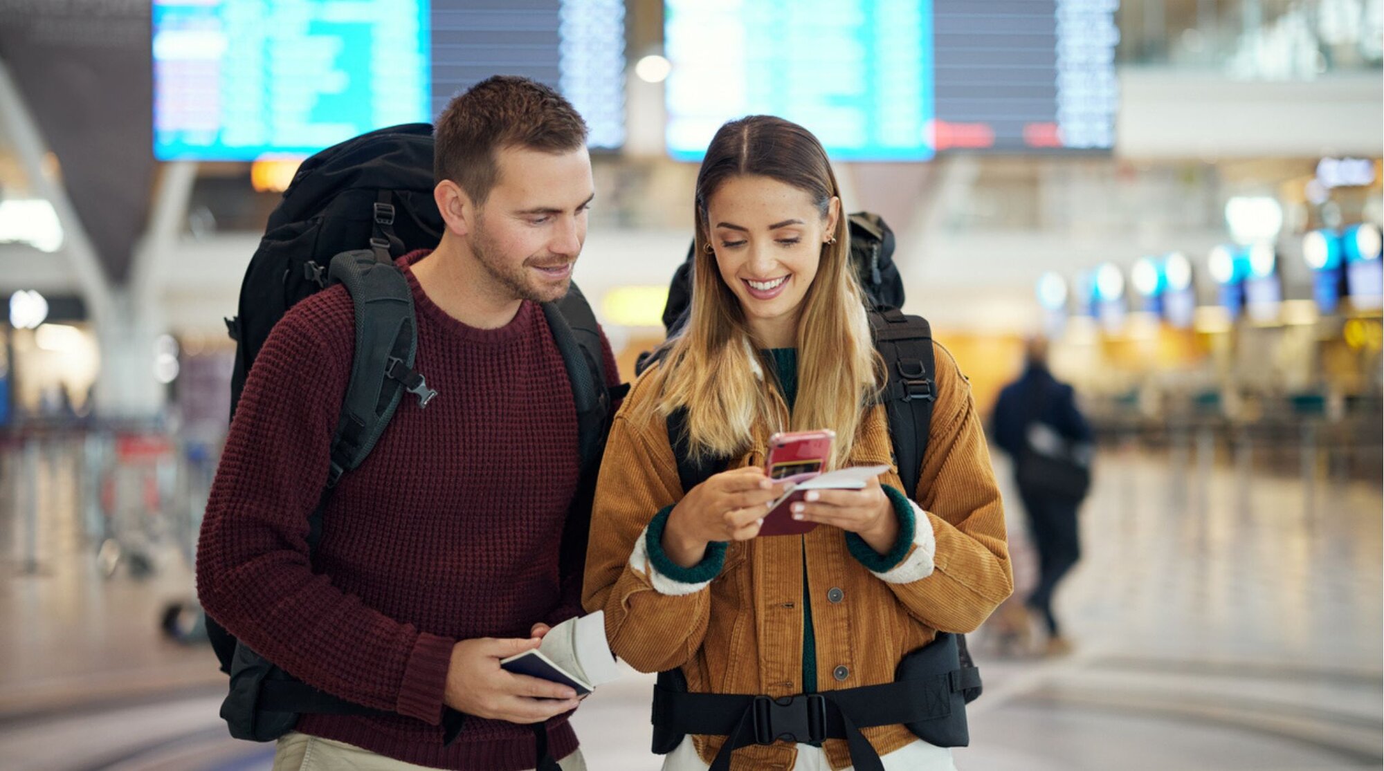 Couple de voyageurs utilisant un téléphone à l’aéroport
