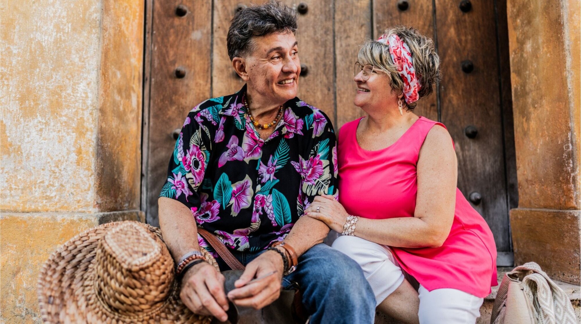 Pareja de adultos mayores conversando en una acera en Cartagena, Colombia.