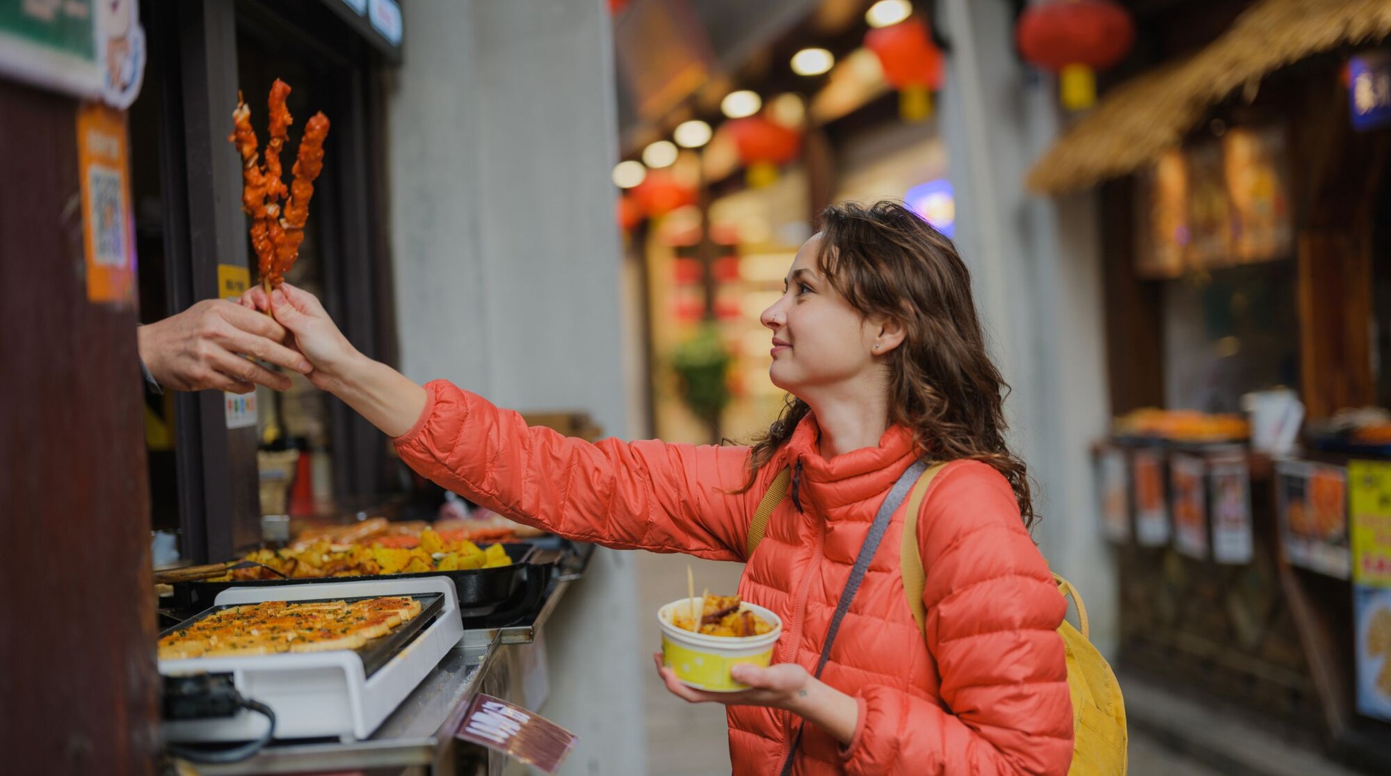 Eine Touristin bezahlt an einem Essensstand in China