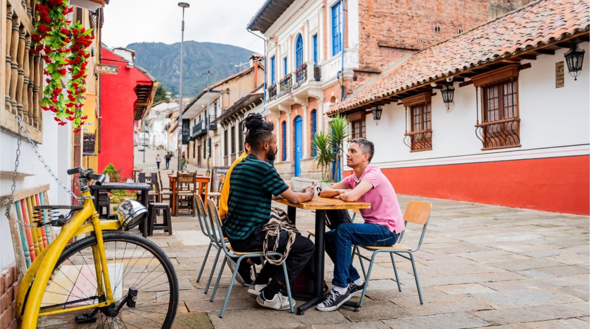Grupo de amigos conversando en una mesa de café al aire libre durante un viaje por Colombia.