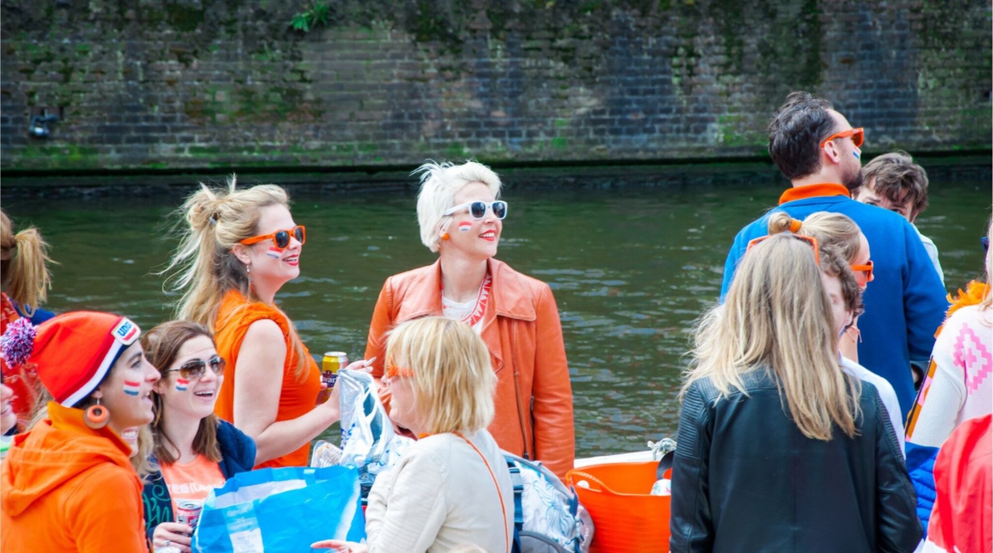 Jovens holandeses em um barco durante King's Day em Abril