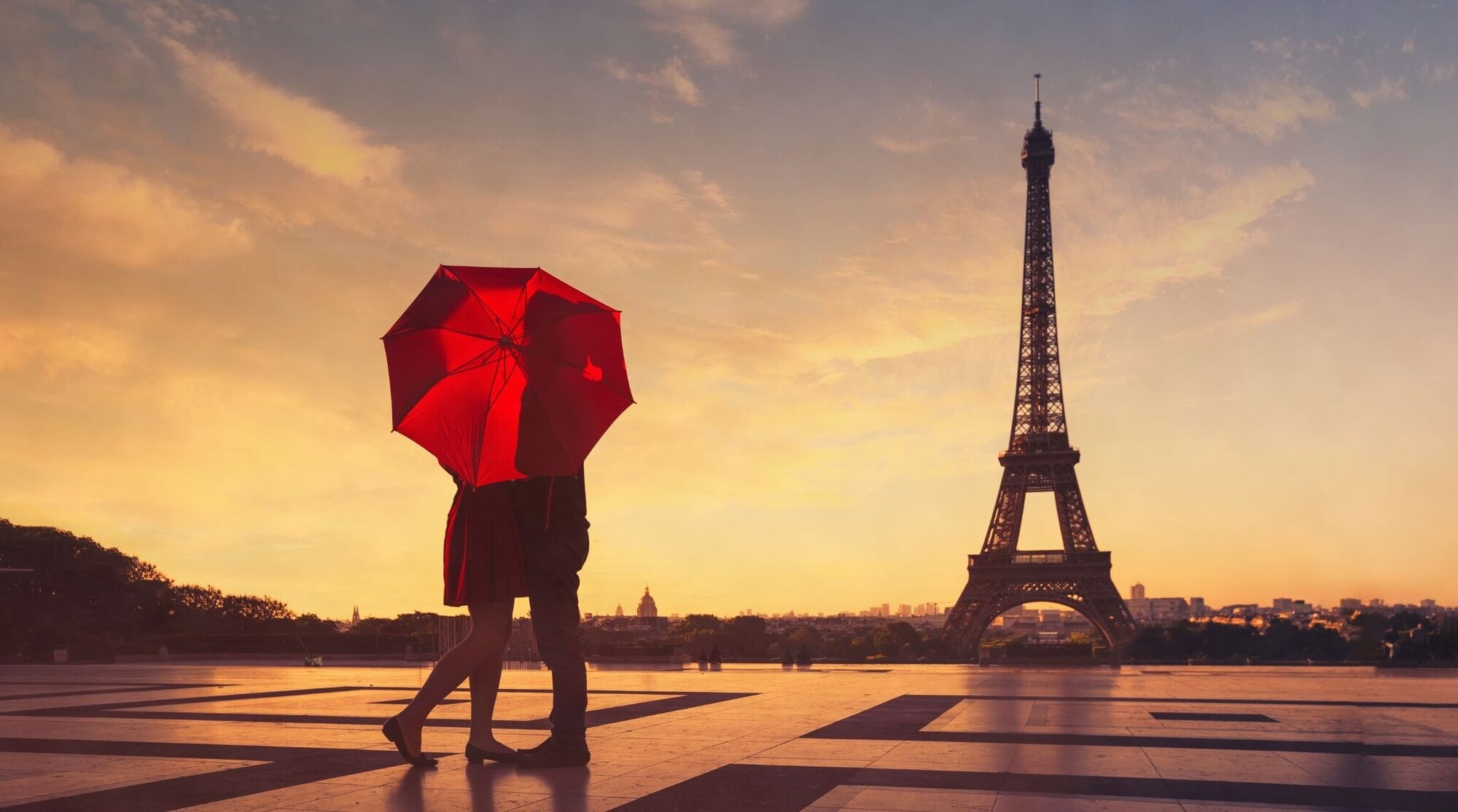 Coppia che si bacia davanti alla Torre Eiffel a Parigi, meta romantica ideale dove andare a San Valentino nel 2027.