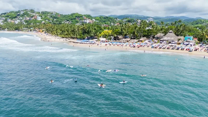 Surfistas esperando el oleaje en la playa de Sayulita, pueblo costero en Nayarit, México.
