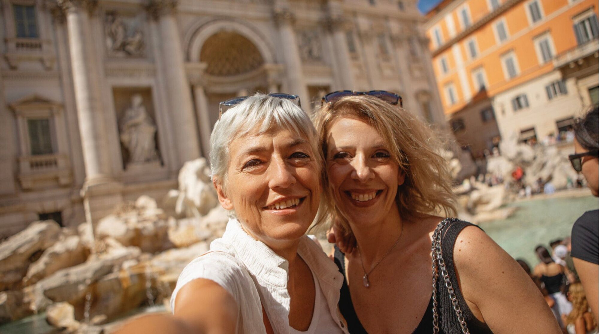 Duas amigas turistas aproveitando um dia de turismo em Roma, Itália, tirando fotos na Fontana di Trevi