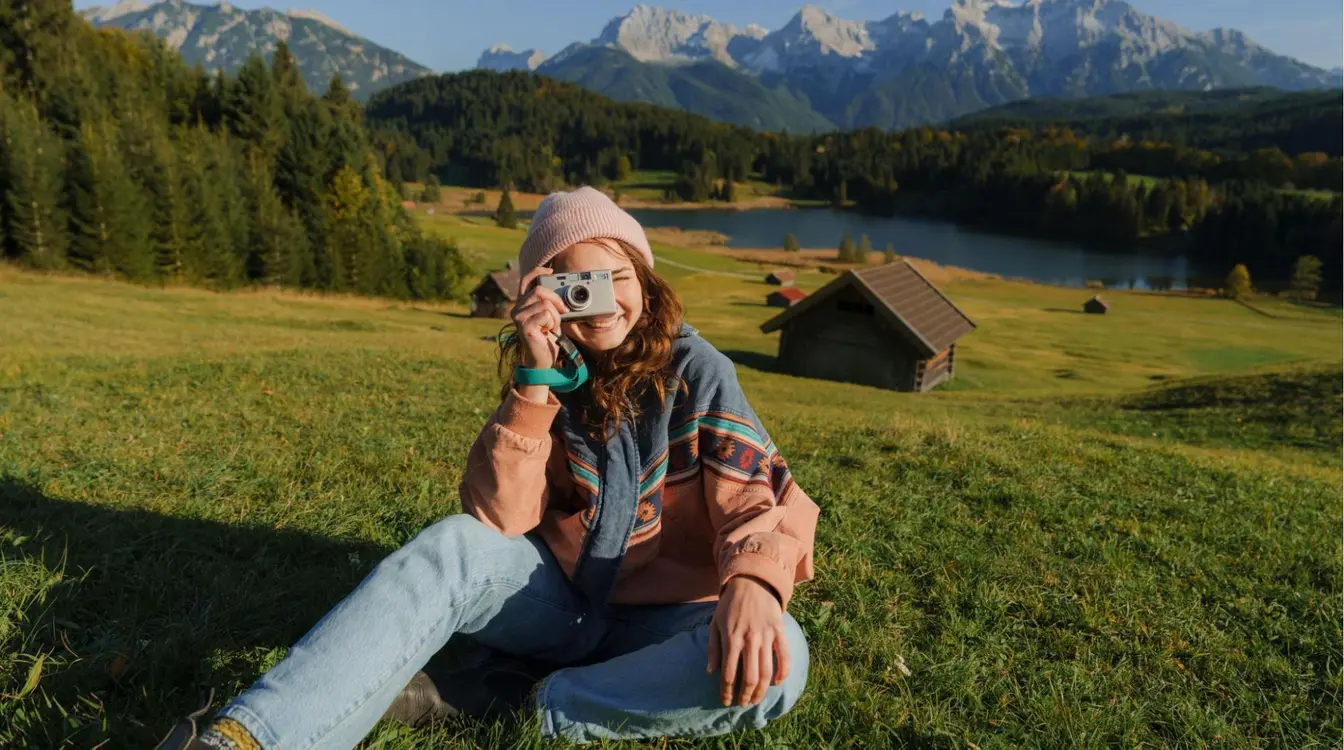 Mulher que faz memórias com câmera de filme durante viagem à Baviera no outono.