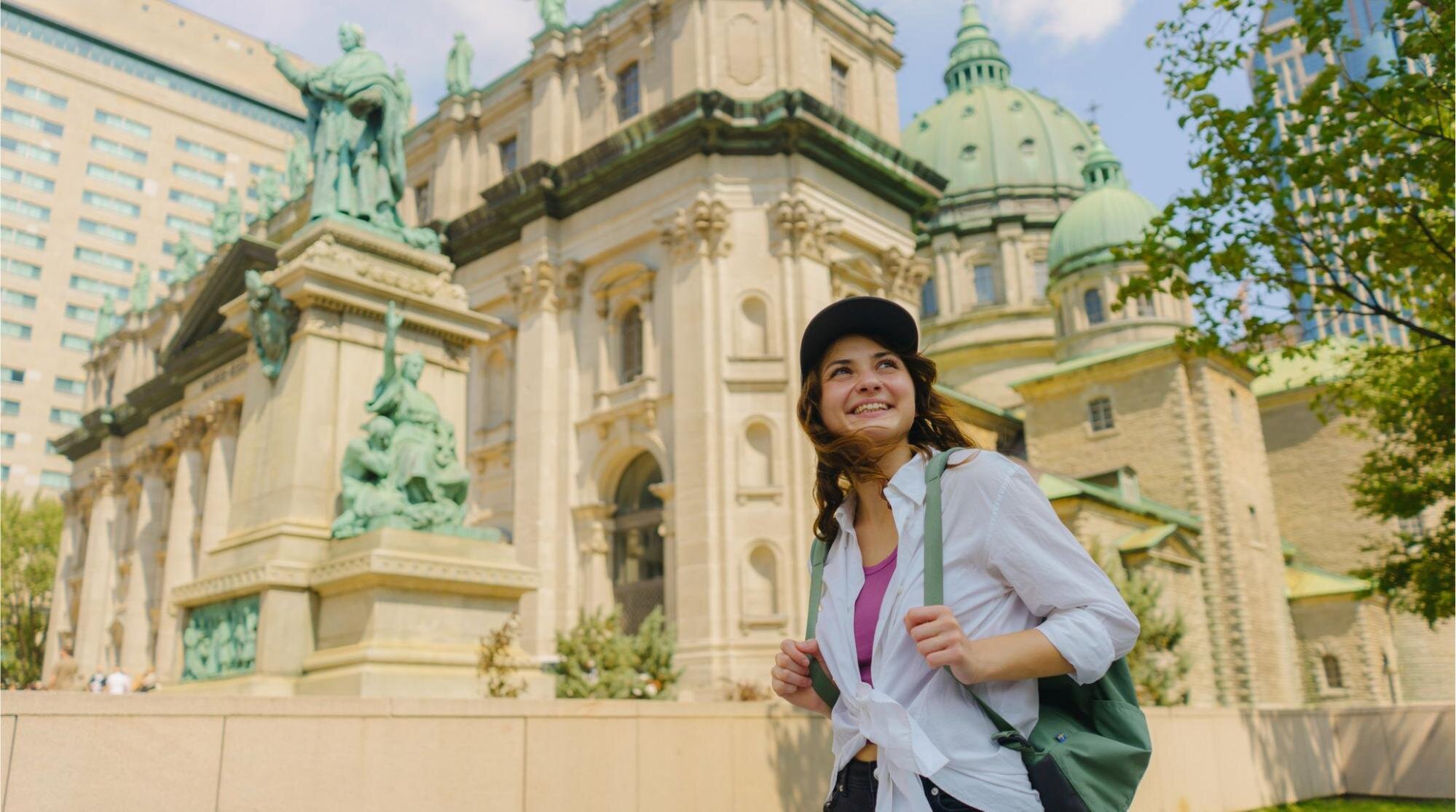 Turista andando no centro de Montreal olhando para a arquitetura e aproveitando o verão na cidade.