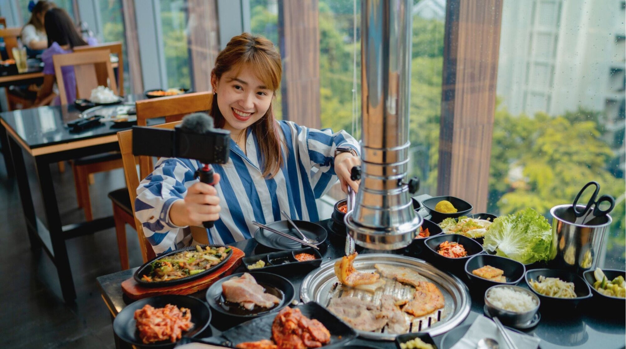 Câmera para vlog com tela articulada sendo segurada por uma mão.