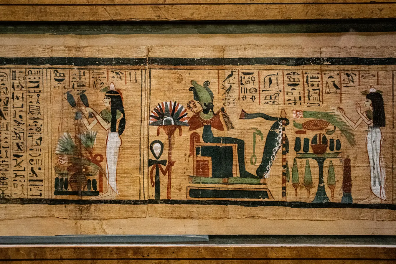 Imagen de un papiro egipcio que combina texto en jeroglíficos y escenas ilustradas con figuras de la mitología para ilustrar la mejor eSIM para Egipto.