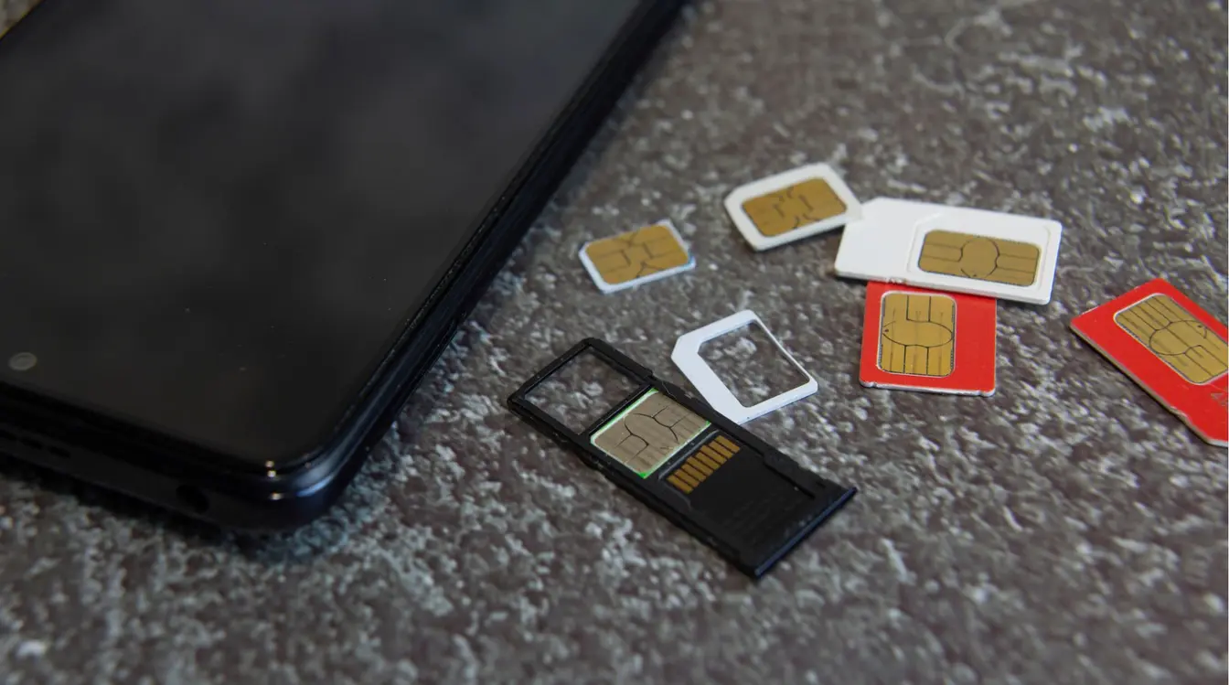 Cartes SIM physiques posées à côté d’un smartphone.