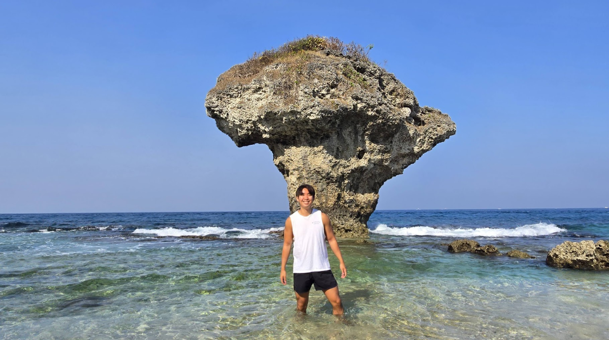 Man standing in front of Vase Rock (花瓶石) on Xiaoliuqiu