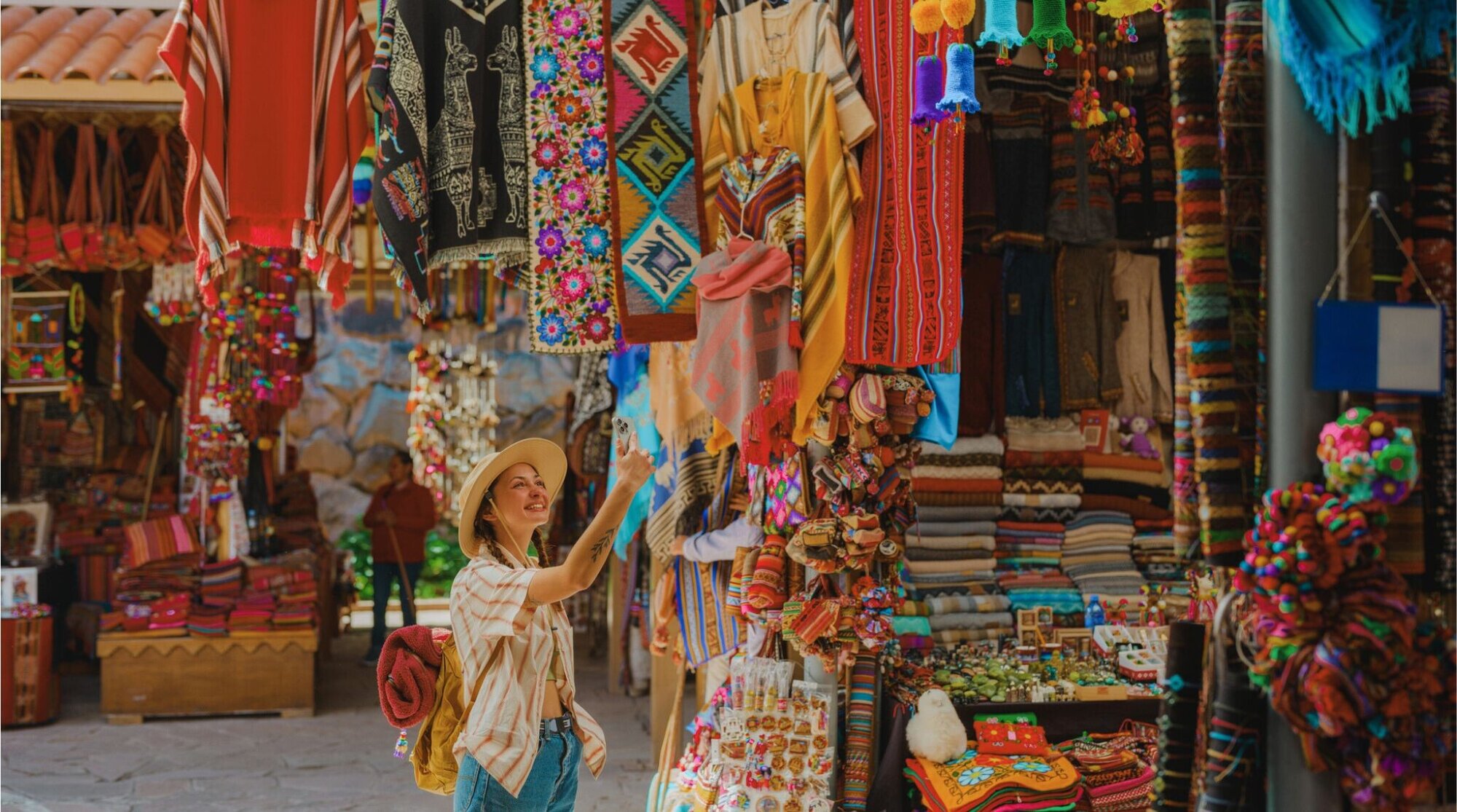 Turista fotografando itens de artesanato em uma loja em Cusco.