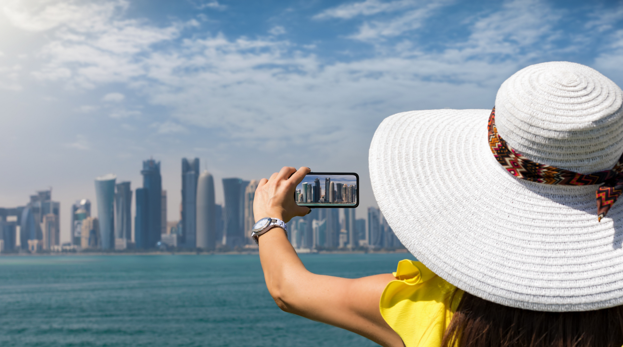 Paesaggio urbano con lo smartphone dal mare contro il cielo