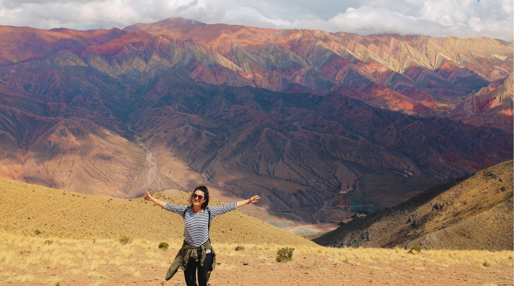 Turista jovem posando entre as deslumbrantes paisagens montanhosas de Purmamarca, Jujuy/Mendoza, Argentina.