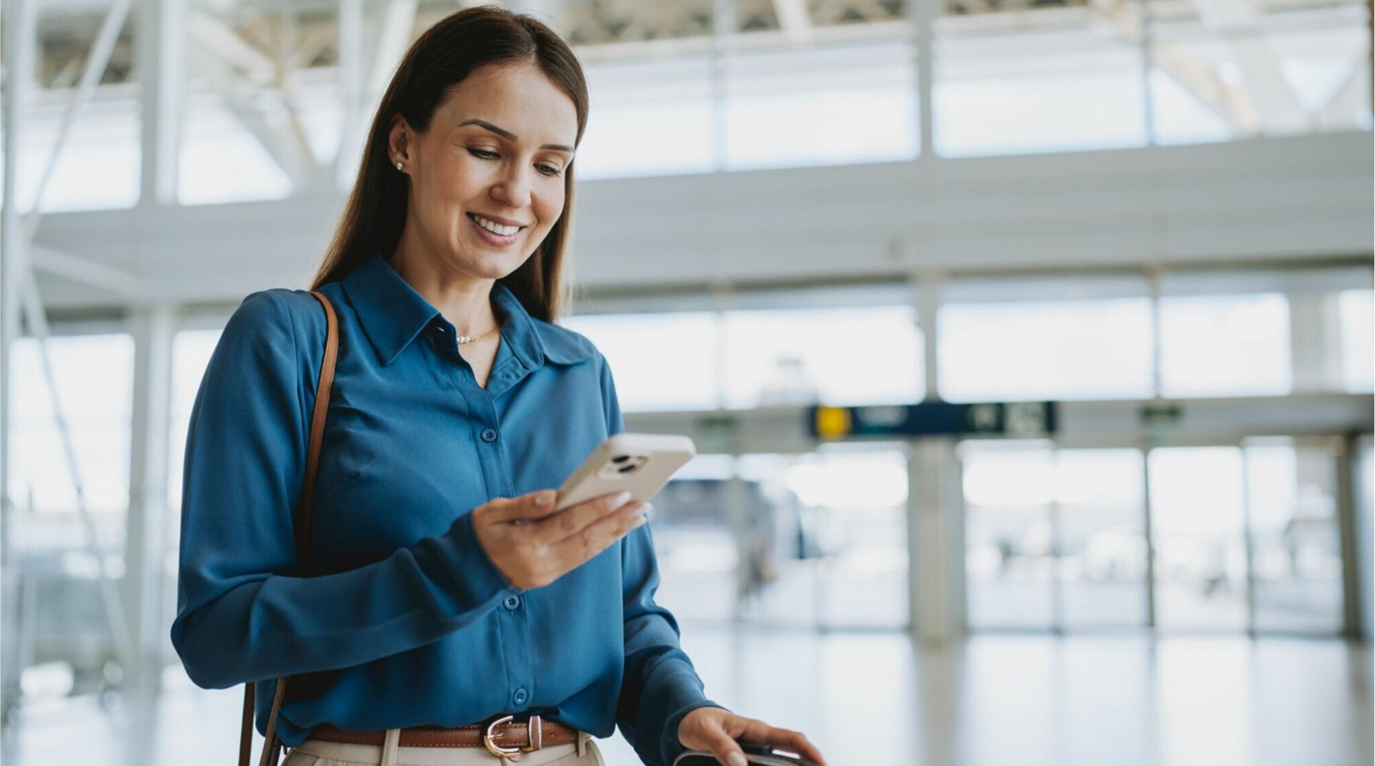 Mulher usando celular com eSIM no aeroporto