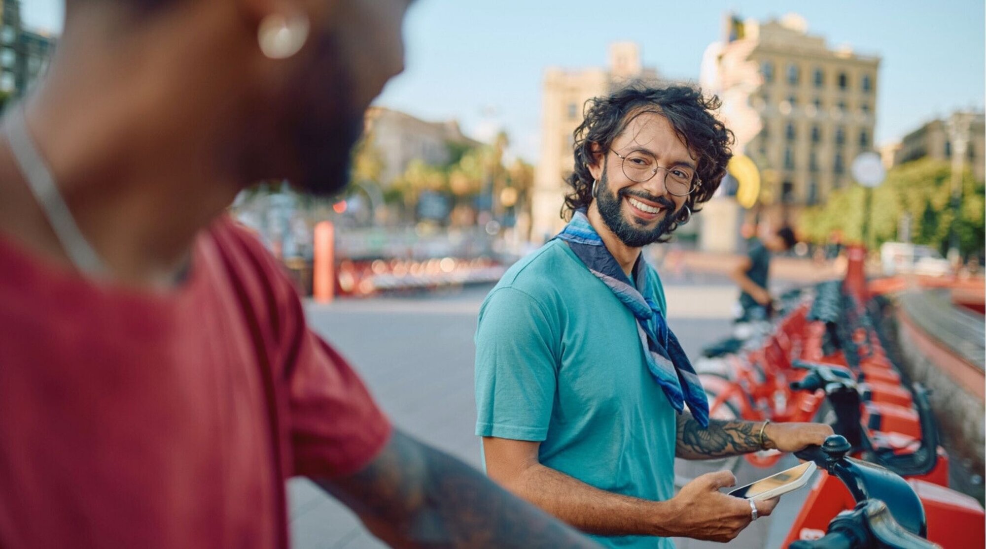 Viajero usando una app en el celular para alquilar un patinete eléctrico en Barcelona.