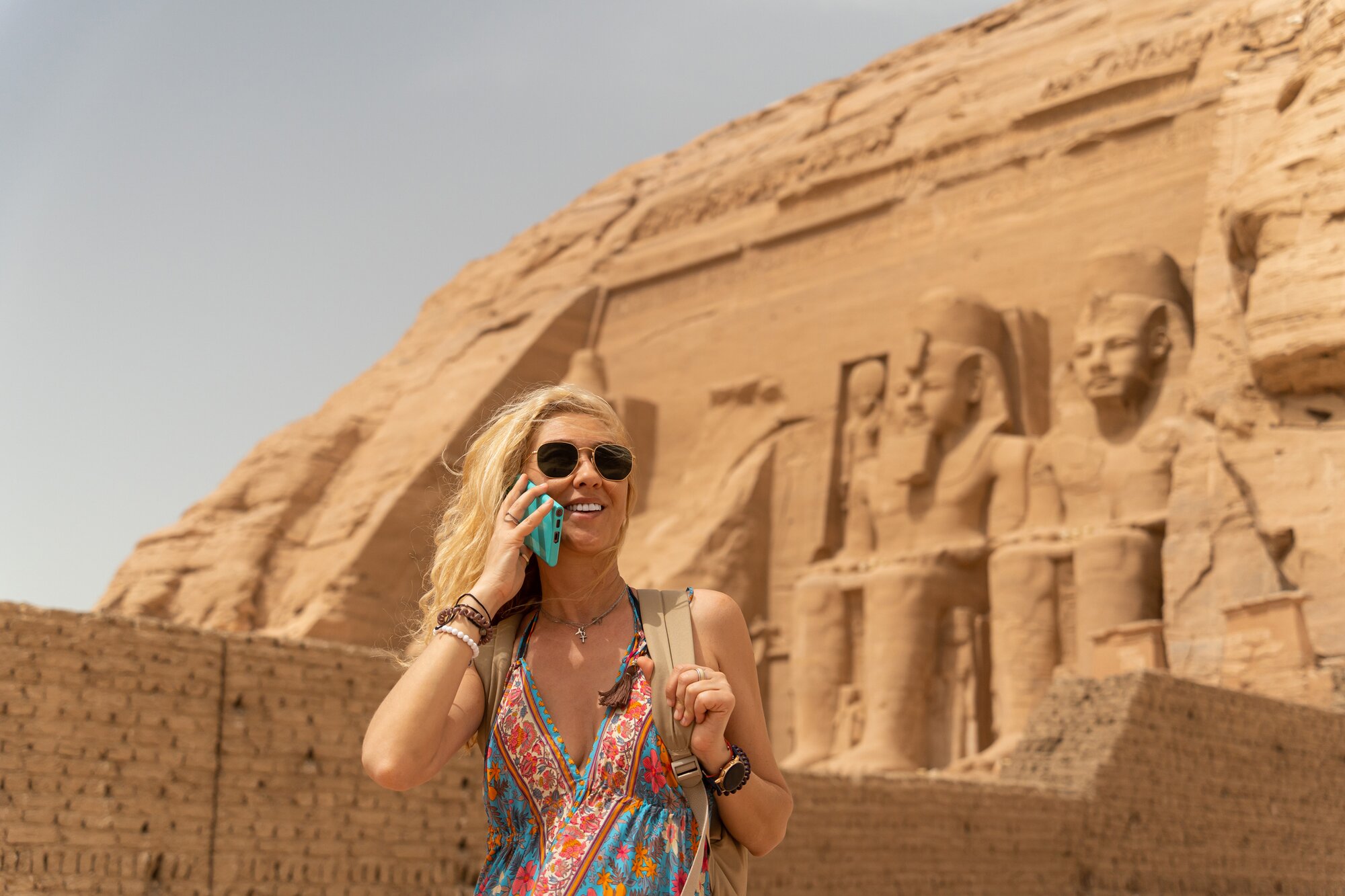 Eine Frau macht einen Anruf mit SIM-Karte vor den Pyramiden in Ägypten