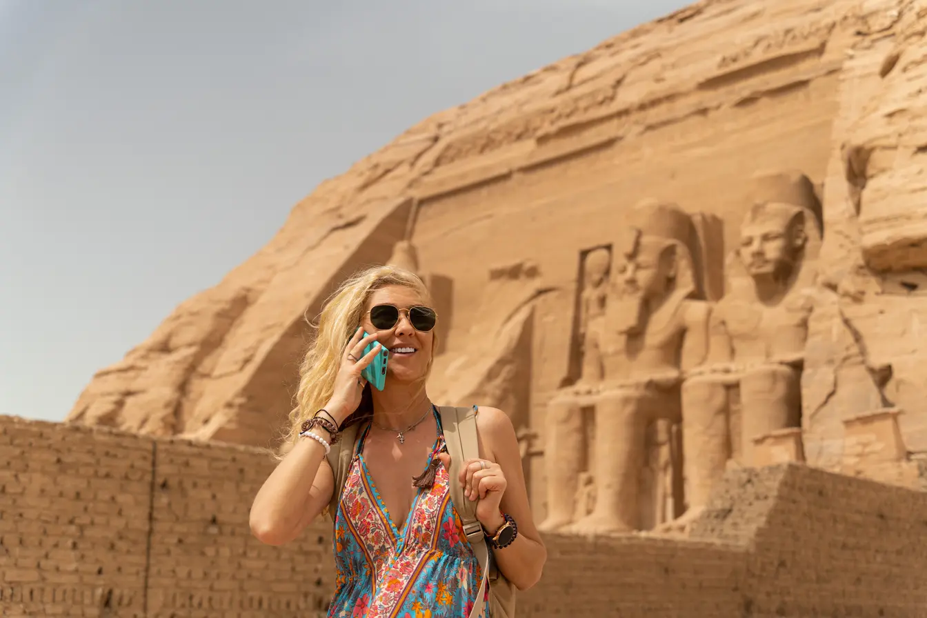 Eine Frau macht einen Anruf mit SIM-Karte vor den Pyramiden in Ägypten