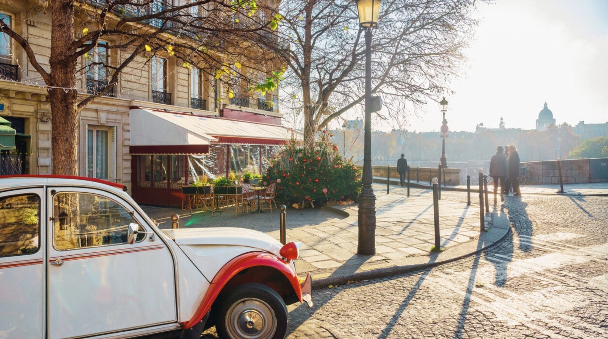 Auto vintage francés estacionado en una calle de París con arquitectura clásica y ambiente invernal.