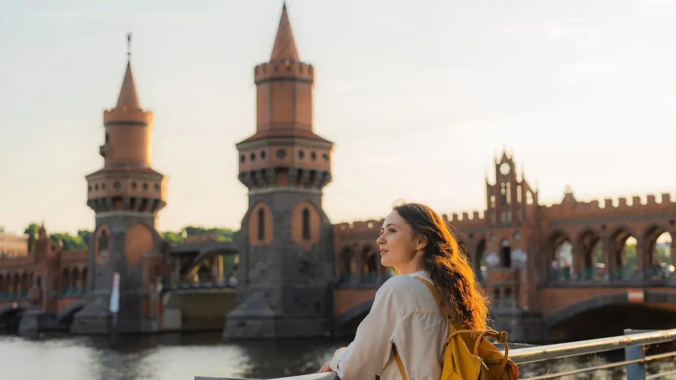 Eine Frau hat eine Kurztrip-Idee und steht in Berlin am Wasser