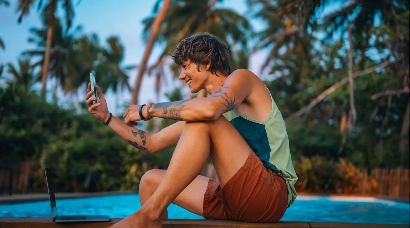Digital Nomad travaillant sur un ordinateur au bord d’une piscine en Thaïlande.