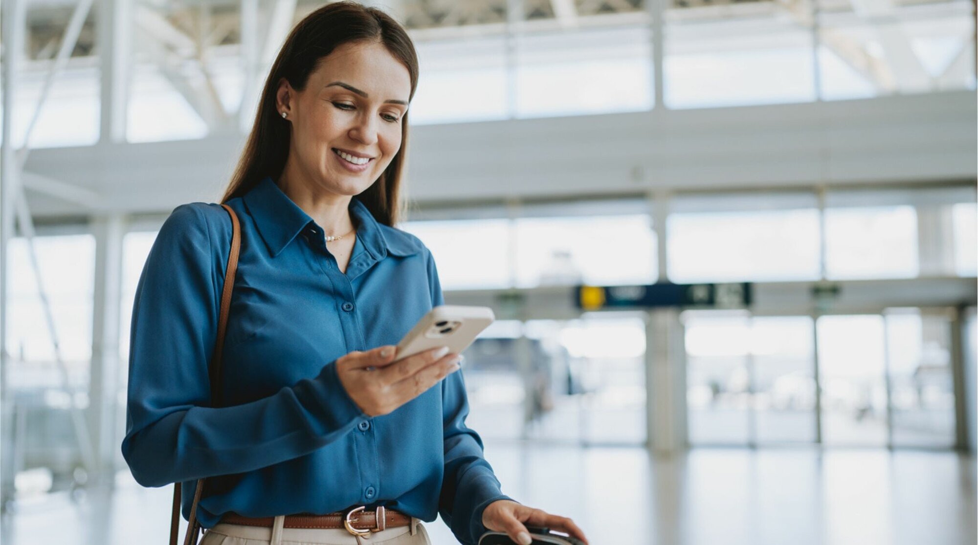 Mujer usando el telefono en un aeropuerto