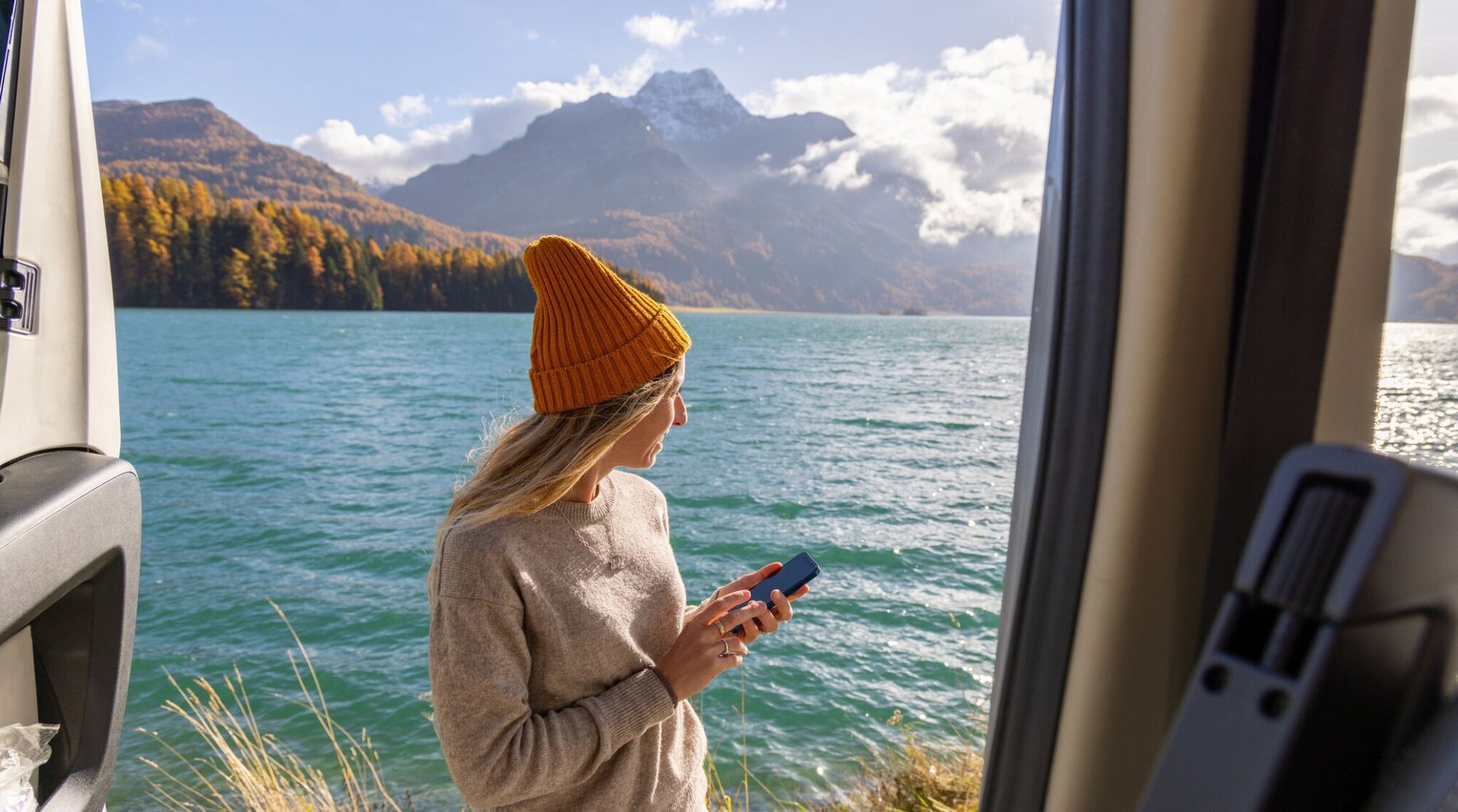 femme a l'arriere de son van, utilisant ses données mobiles en voyage