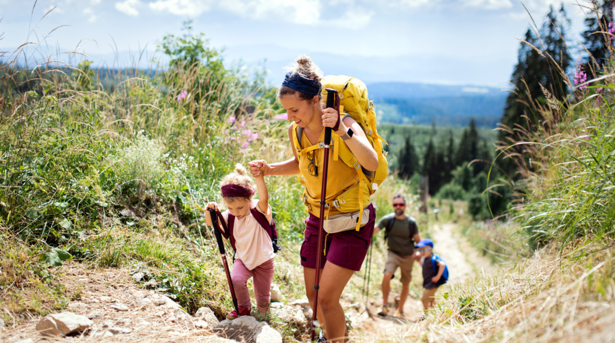 Famiglia con bambini piccoli che camminano all'aperto nella natura estiva