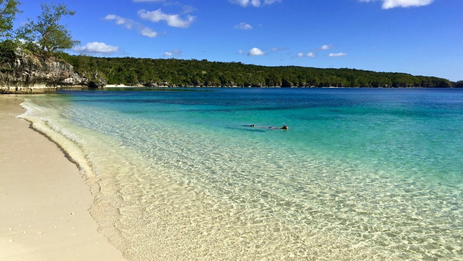 Person snorkelling in the turquoise beach water