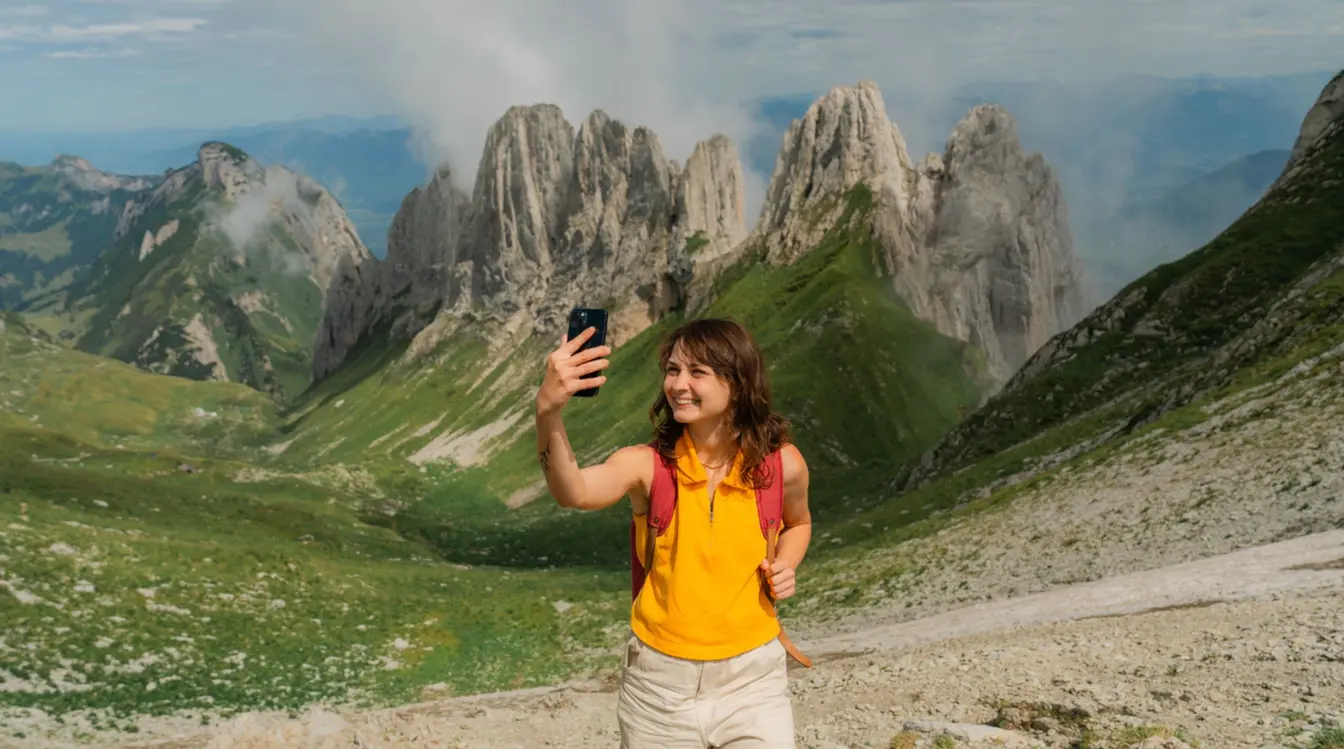 Frau mit einer eSIM macht Selfie auf einer Wanderung in den Appenzeller Alpen in der Schweiz