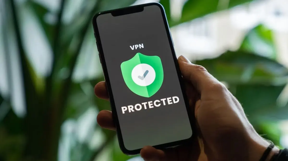 Una persona sostiene su teléfono con la pantalla mostrando el mensaje "VPN Protected".