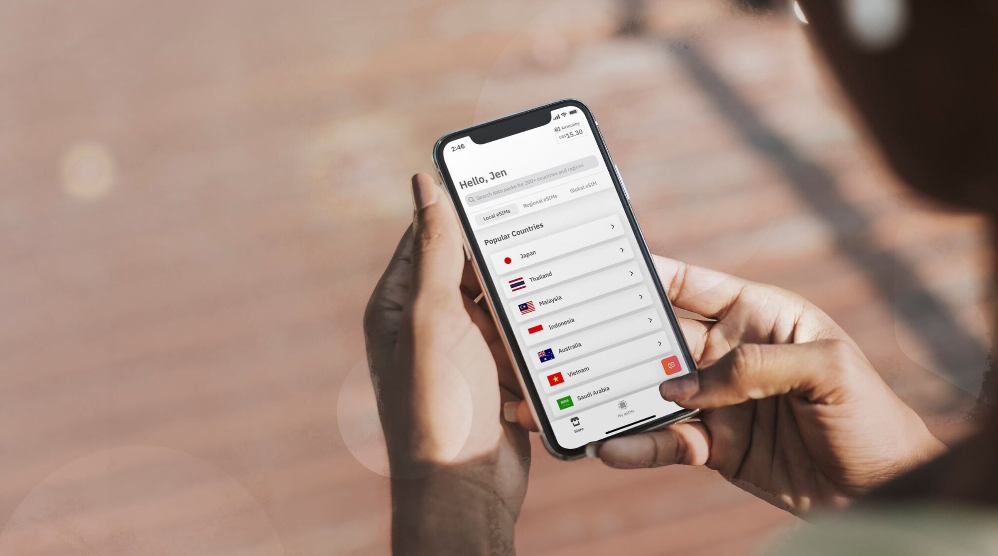 امرأة تحمل iPhone مع تطبيق Airalo يعرض بطاقات الكترونية (بطاقات eSIM) 