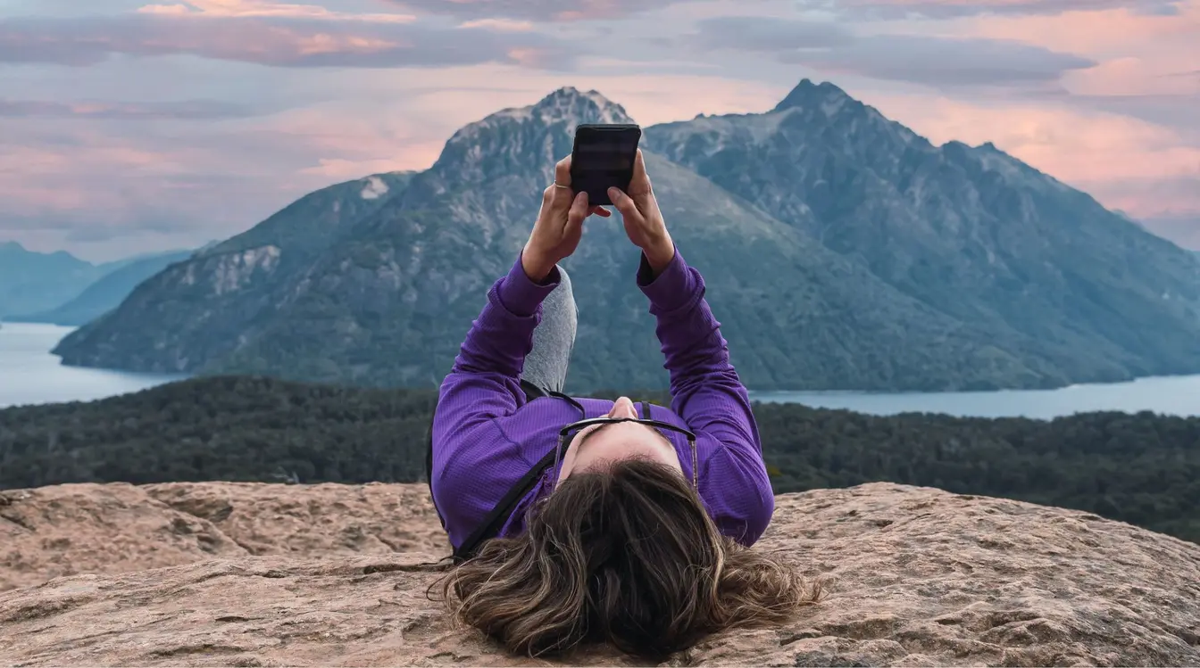 Donna che usa lo smartphone in una foresta montuosa in Argentina con connessione internet mobile durante il viaggio