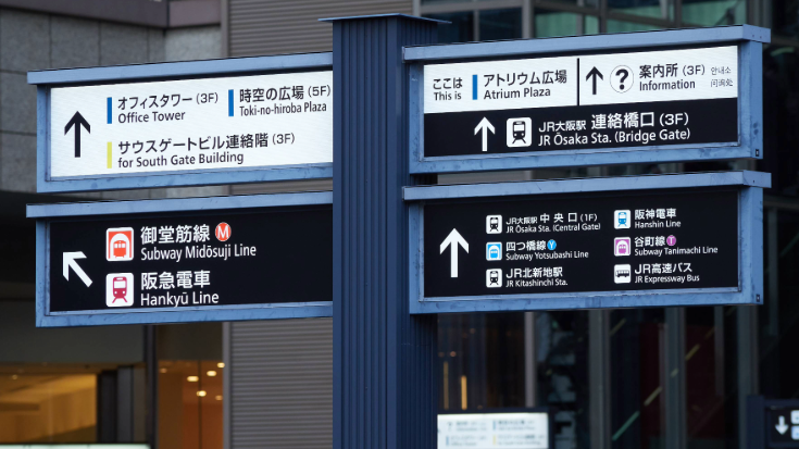 An image of some street signs outside a railway Station in Osaka, showing specifically directions for the Midosuji Line, highlighted in red, which is the line attendees of the Summer Sonic Festival need to take to the concert venue.  