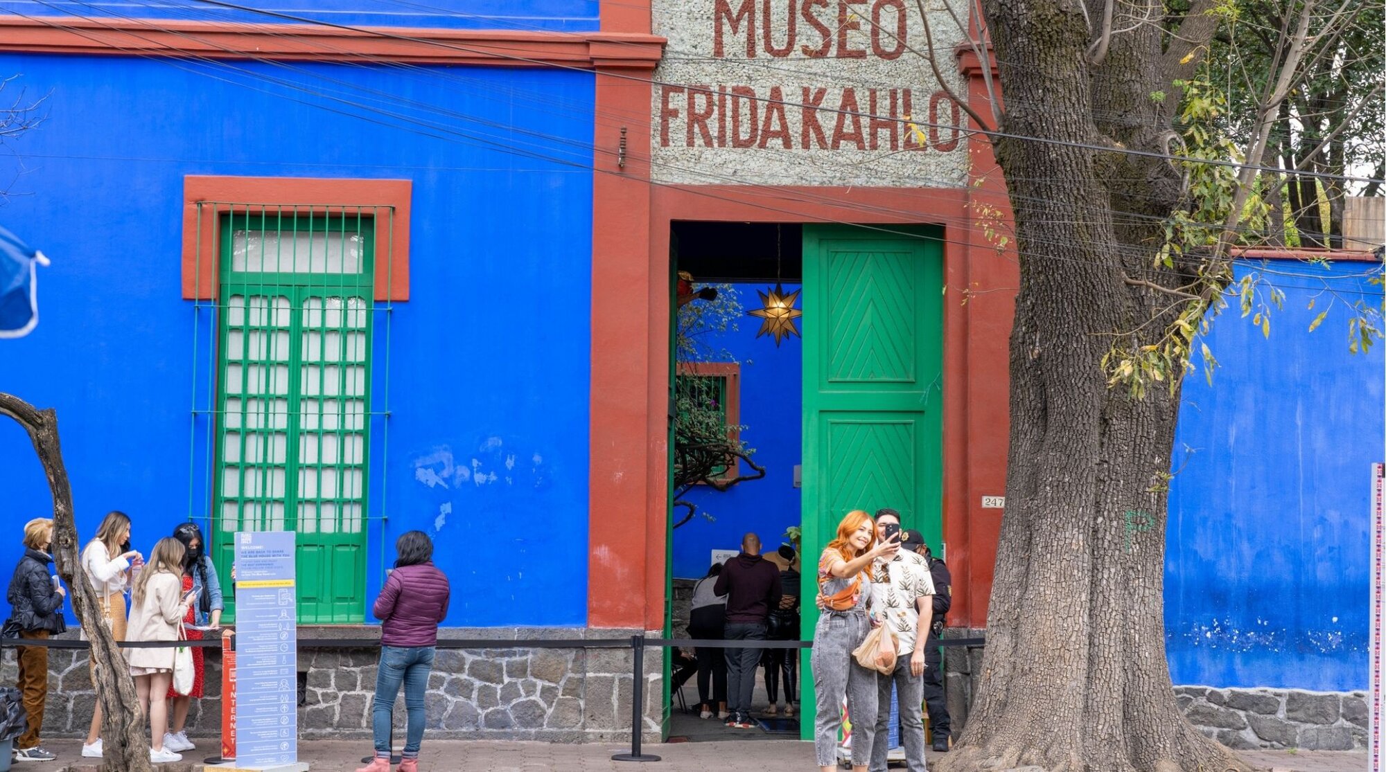 Turistas tirando fotos na porta da casa azul, onde fica o Museu Frida Kahlo, no bairro Coyoacan na Cidade do México.