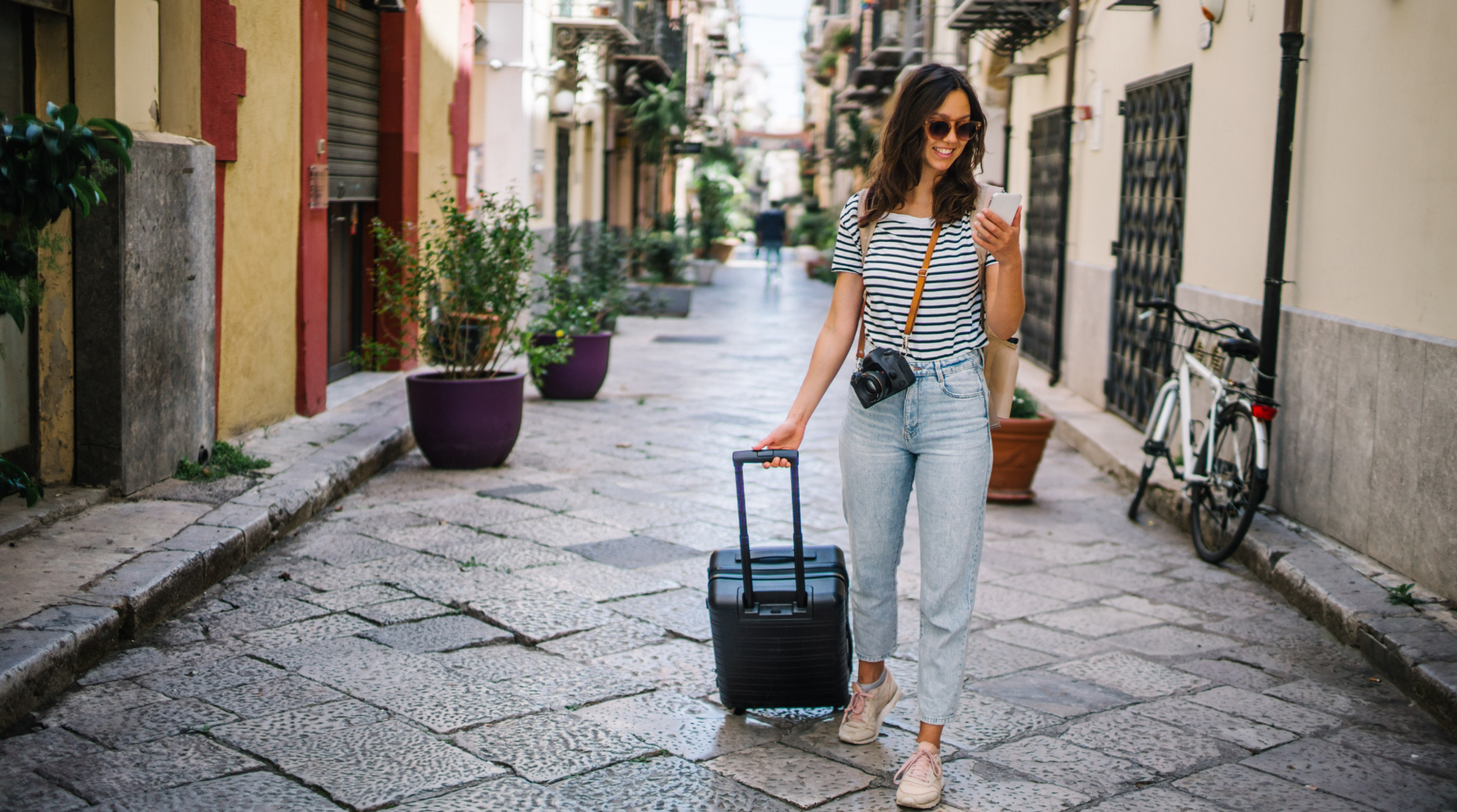Eine junge Frau läuft mit Internet in Italien durch eine kleine Gasse