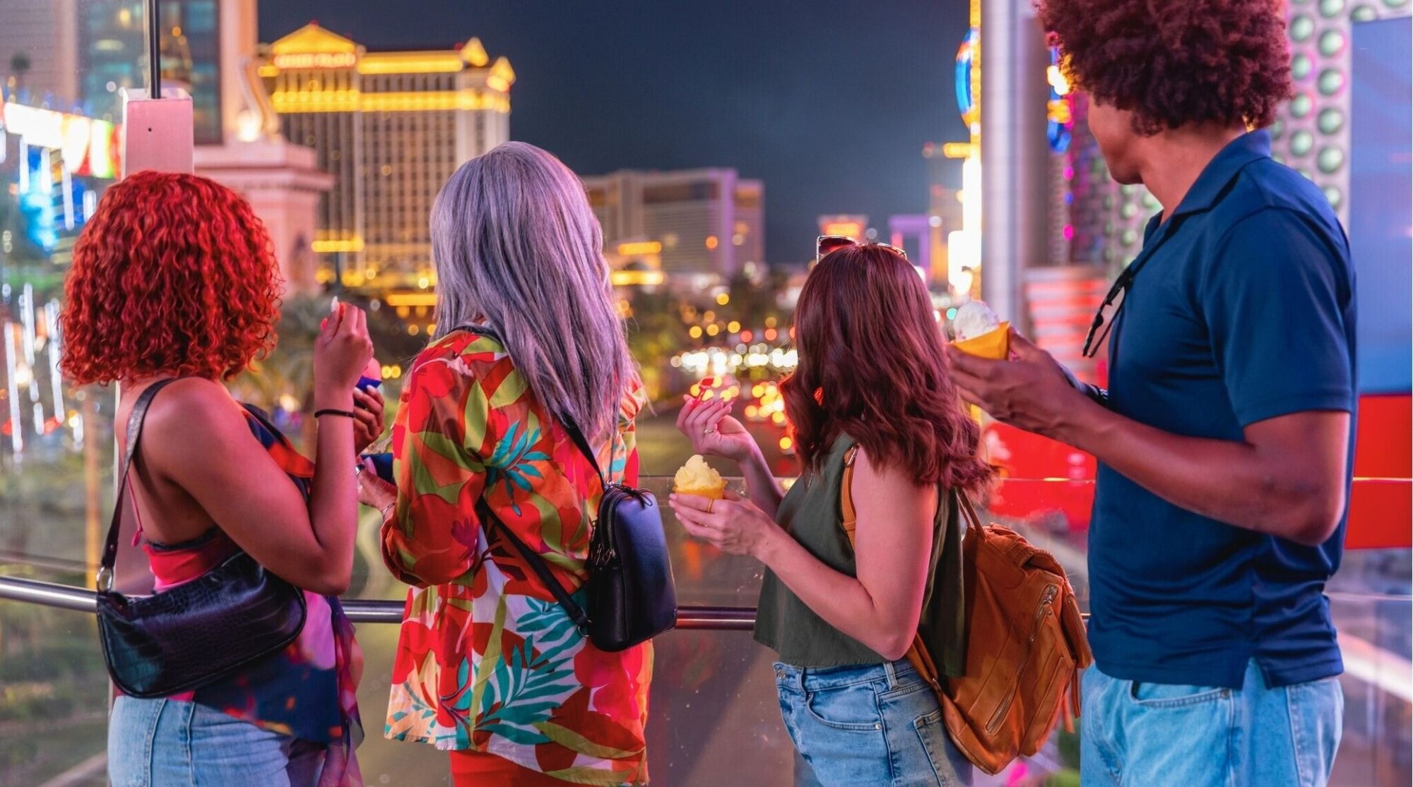 Grupo mirando luces del Strip de Las Vegas de noche, viaje y ocio.