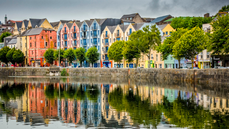 Colourful blue, orange and yellow three and four-storey houses line the River Lee in Cork.