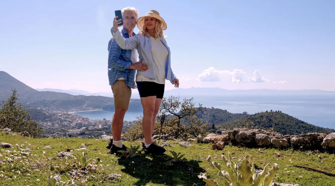Älteres Paar macht ein Selfie auf dem Hügel über dem Meer
