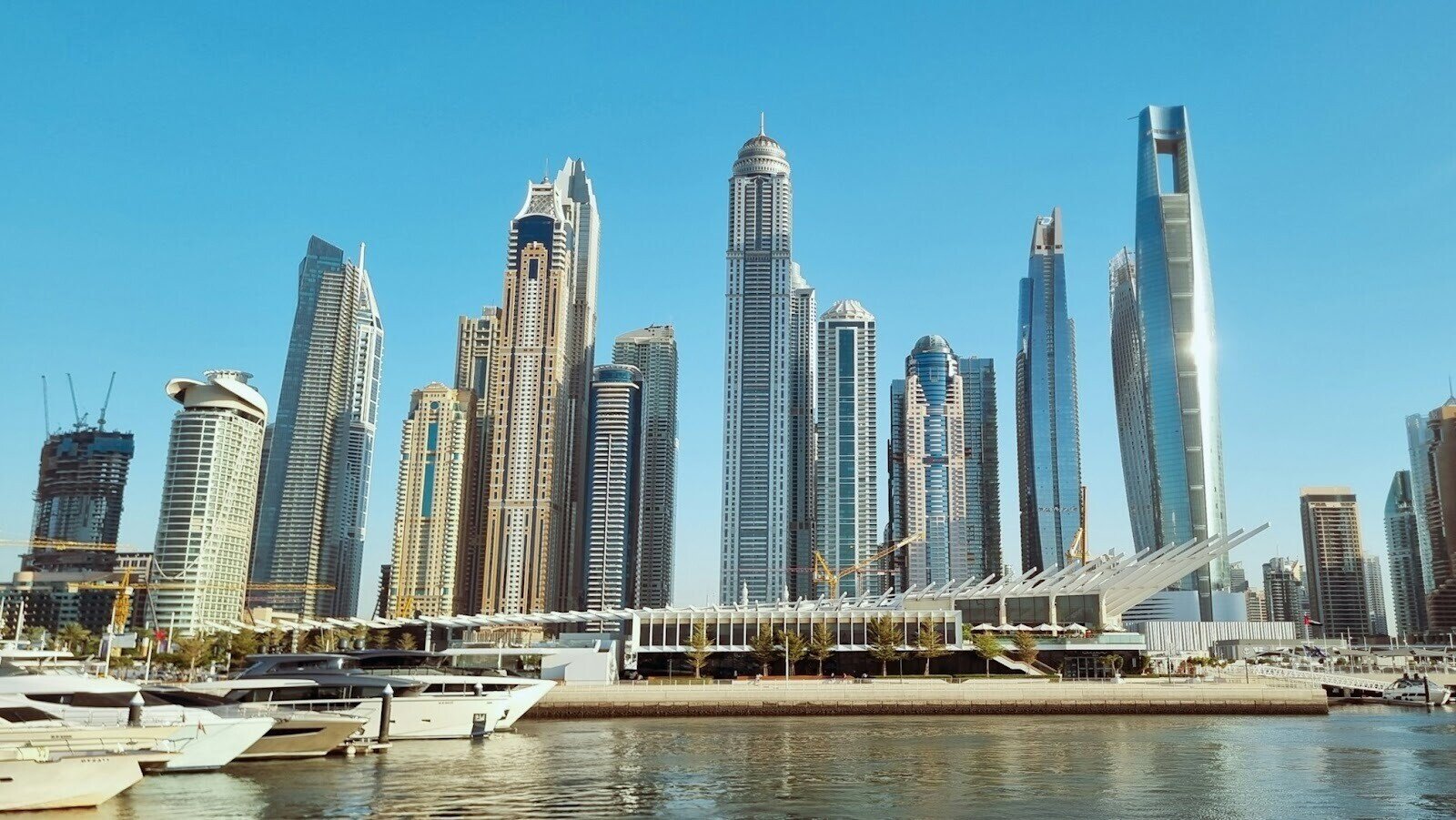 Boats on a large body of water surrounded by high-rise buildings in Dubai