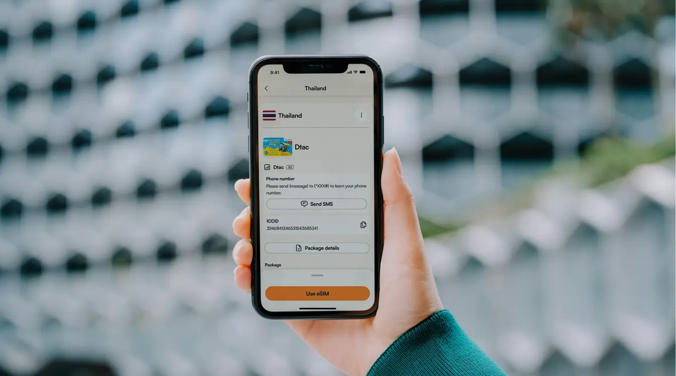Viajante com celular em mãos e app da Airalo aberto para comprar um chip internacional.